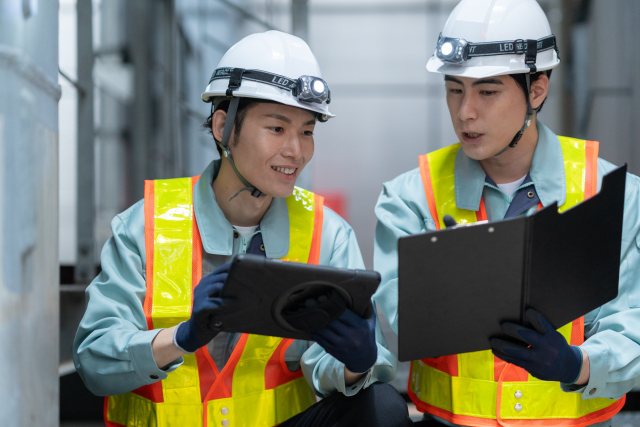 工場でタブレットを使って作業をする作業員